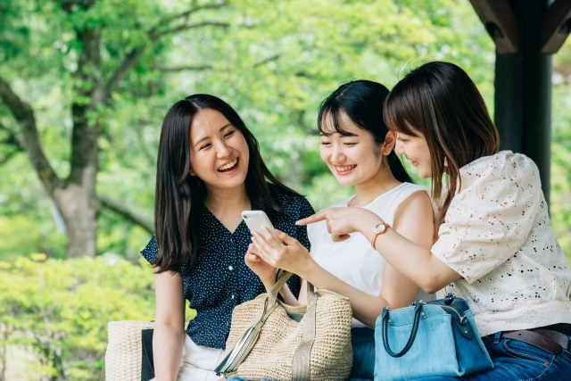 スマホを見て談笑する女子たち 視野が広いと恋愛にも有利!視野が広い人の特徴