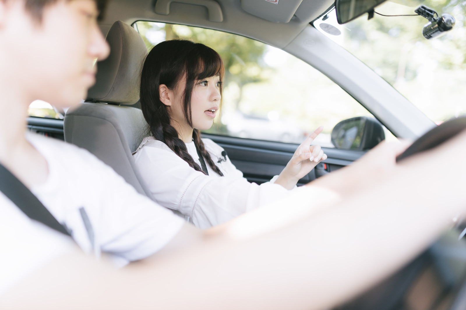 車に乗って指を指す女性 車に乗って指を指す女性